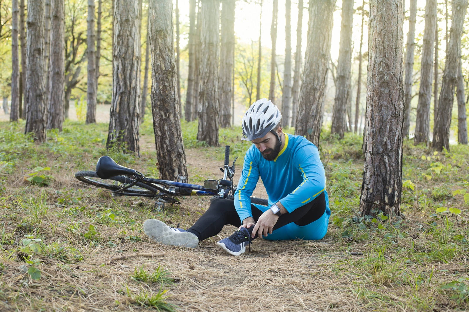 Ein Mann ist mit seinem Fahrrad im Wald gestürzt. 