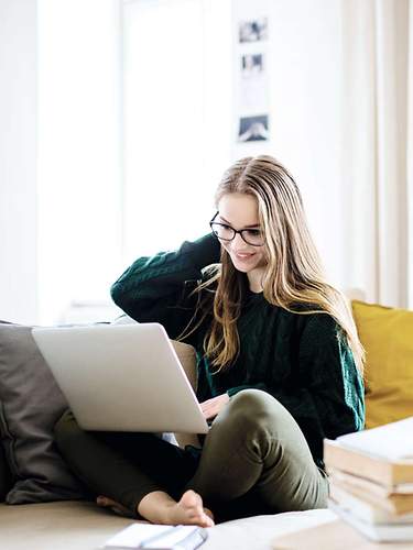 Unfallversicherung wechseln: Frau auf Sofa – Header-Bild