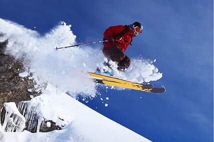 Skiunfallversicherung: Skifahrer auf der Piste beim Absprung