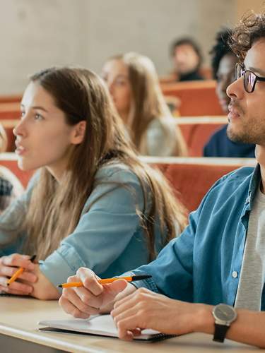 Versicherungen für Studenten. Eine Gruppe von Studenten spaziert über einen Weg.